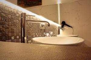 a bathroom with a white sink and a mirror at Suite Bacco Ortigia in Siracusa