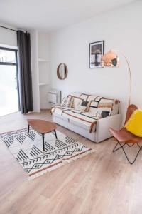 - un salon avec un canapé et une table dans l'établissement Modern Air Conditioned Apartment, à Bordeaux
