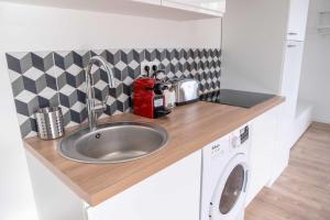 - un comptoir de cuisine avec évier et four micro-ondes dans l'établissement Modern Air Conditioned Apartment, à Bordeaux