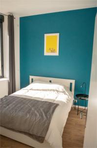 - une chambre avec un mur bleu et un lit dans l'établissement Modern Air Conditioned Apartment, à Bordeaux