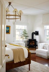 1 dormitorio con 1 cama y chimenea en Kennebunkport Captains Collection, en Kennebunkport