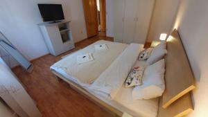 a large bed in a small room with a television at Vila Panselutelor 6 in Sinaia