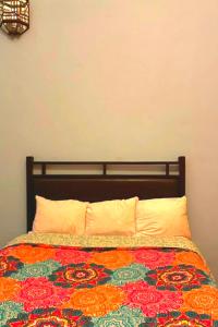 a bed with a colorful blanket and pillows on it at Alebrije Hotel Boutique in Guadalajara