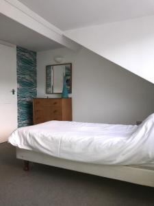 a white bed in a room with a staircase at High Tide in Whitby