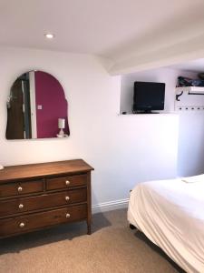 a bedroom with a bed and a dresser and a mirror at High Tide in Whitby