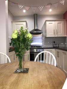 a kitchen with a wooden table with a vase of flowers on it at High Tide in Whitby