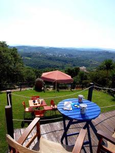 Villa Papoura Homeleader في Delimanolianá: طاولة زرقاء وكراسي على سطح خشبي