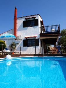 a large swimming pool in front of a house at Villa Papoura Homeleader in Delimanolianá