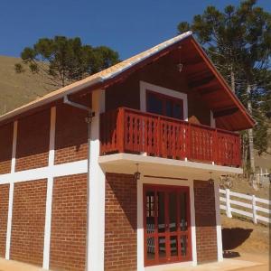 ein kleines Backsteinhaus mit einem roten Balkon in der Unterkunft Recanto Três Irmãs in Companhia