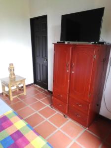 un armario rojo con un televisor encima. en Casa Finca La Pintada en Montenegro