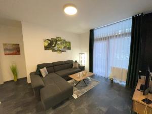 a living room with a couch and a table at Mariposa 4 incl Pool & Sauna in Bad Harzburg