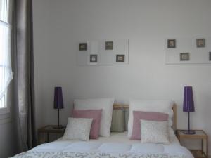 イシニー・シュル・メールにあるLe Pont de l'Aureのベッドルーム1室(ピンクと白の枕が備わるベッド1台付)