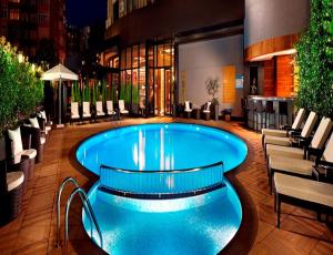 a pool in a hotel lobby with chairs and tables at Surmeli Istanbul Hotel in Istanbul