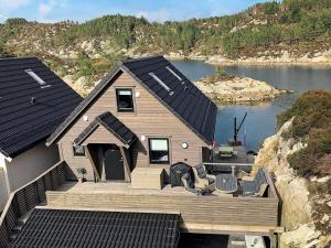 a house with a large deck and a body of water at 8 person holiday home in Urangsv g in Ervik