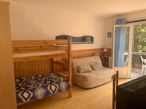 sypialnia z 2 łóżkami piętrowymi i kanapą w obiekcie Les studios de l'Océan w mieście Les Mathes