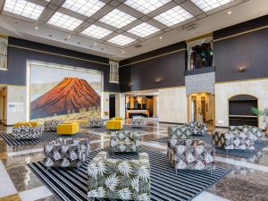高松的住宿－APA酒店高松機場店，大堂设有椅子和墙上的绘画作品