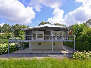a house with a balcony and chairs on it at Holiday Home in Kamperland by Veerse Meer in Kamperland