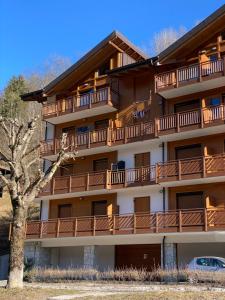 ein Apartmenthaus mit Balkon und einem Baum in der Unterkunft Residenza al Parco Termale - Comano Terme in Comano Terme