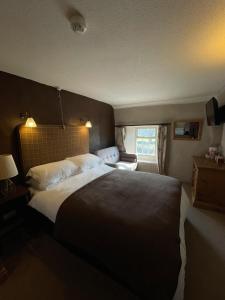 a bedroom with a large bed and a window at Queens Arms Litton in Litton