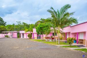 una hilera de casas rosas con palmeras en Pousada do Recanto Feliz, en Torres