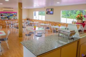 un restaurante con mesas y sillas en una cafetería en Pousada do Recanto Feliz, en Torres