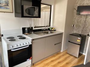 a small kitchen with a stove and a sink at Windsor Motel in Taupo