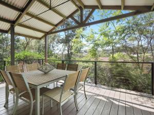 a patio with a table and chairs on a deck at Charming Beach Home with Plenty of Outdoor Spaces in Avoca Beach