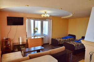 a living room with a couch and a bed and a tv at Apartment Naberezhnaya 20 in Petropavlovsk-Kamchatskiy