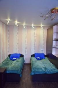 ペトロパブロフスク・カムチャツキーにあるApartment Tushkanova 3の青い枕が備わる客室内のベッド2台