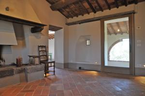 een lege kamer met een groot raam en een stoel bij Podere Palazzo in Castiglione dʼOrcia