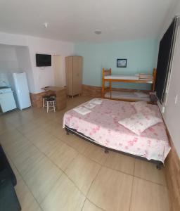 een slaapkamer met een bed en een houten vloer bij Pousada do Recanto Feliz in Torres