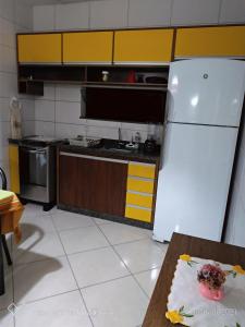 uma cozinha com um frigorífico e uma mesa em Condomínio Bella Vista em Porto Seguro