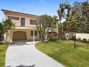 a house with a driveway and a yard at Beachfront Delight - 14b Bareena Avenue in North Avoca