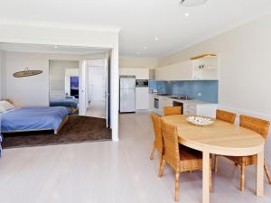 een keuken en eetkamer met een tafel en een bed bij Comfy Beachfront Unit, Unbeatable Location & Views in Avoca Beach