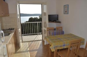 - une cuisine avec une table et une vue sur l'océan dans l'établissement Apartments Petar - 6m from the sea, à Barbat na Rabu