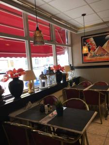 Un comedor con mesa y sillas y ventanas. en Tamar 2, en Katwijk aan Zee 22 fotos más