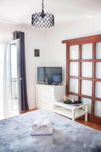 a bedroom with a tv and a bed with towels at Apartments Ante - seaview in Brela