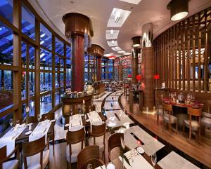 a restaurant with tables and chairs in a room with windows at Surmeli Istanbul Hotel in Istanbul