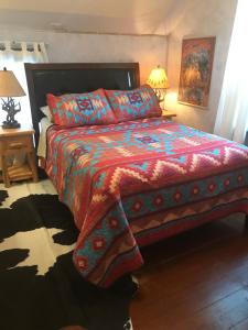 a bedroom with a bed with a colorful comforter at Holiday Lodge Bed and Breakfast in Banff
