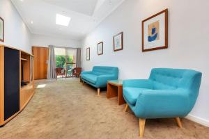 
a living room filled with furniture and a blue couch at Comfort Inn & Suites Sombrero in Adelaide
