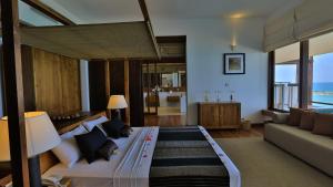 a bedroom with a bed and a couch in a room at Pandanus Beach Resort & Spa in Bentota