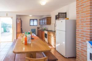kuchnia z drewnianym stołem i białą lodówką w obiekcie House Otusi w mieście Tkon
