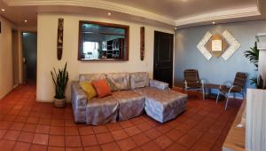 a living room with a couch on a tile floor at Edifício Levi in Torres