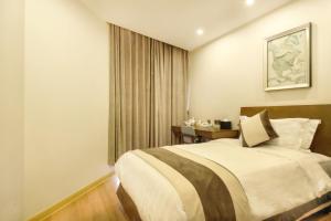 a bedroom with a large bed and a table at Green Court Residence Jinqiao Diamond Shanghai in Shanghai