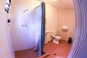 a bathroom with a shower, toilet, and sink at Batchelor Butterfly Farm in Batchelor