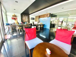 - un restaurant avec 2 chaises et une table avec des oreillers rouges dans l'établissement The Palms Residence - SHA Extra Plus, à Phuket