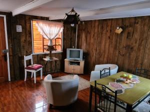 sala de estar con mesa y TV en Cabañas cerca de Valdivia, en San José de la Mariquina, en San José de la Mariquina