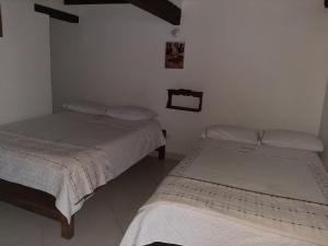 A bed or beds in a room at Cemandy Hostal