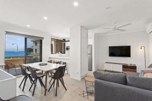 a living room with a table and a couch at Bay Village - Shoal Bay Apartments in Shoal Bay