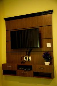 uma televisão de ecrã plano numa parede de madeira em Hotel the Narayani em Maruwā Ghāt